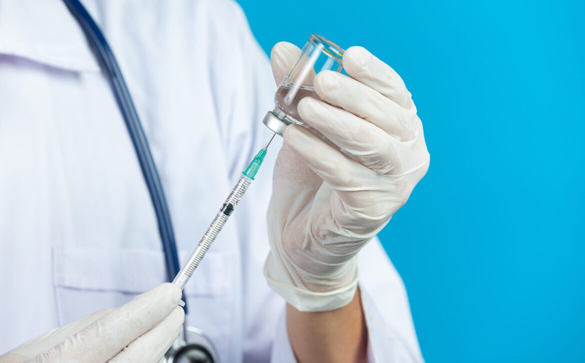 close up picture of docter's hands holding hypodermic syringe